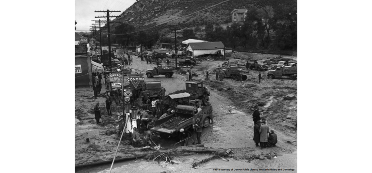 People with shovels gather on the mud and debris covered main street in Morrison after a flood in 1938