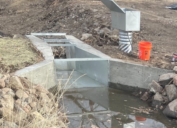A newly constructed metal and concrete flume.