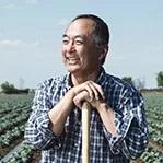 Robert Sakata standing in front of an agricultural field.