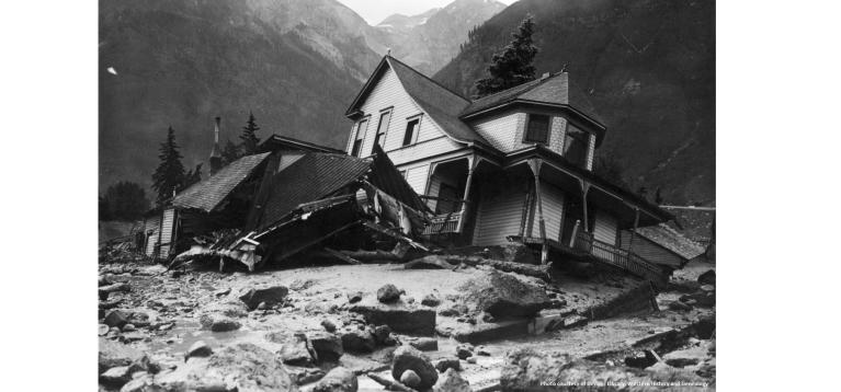 Black and white image of a Victorian house partially destroyed by a flood in Telluride, 1914