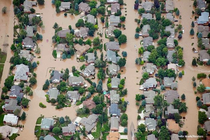 Birds eye view of suburban houses partially submerged by brown flood waters from the 2013 South Platte flood.